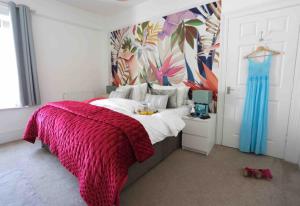 a bedroom with a bed with a red blanket at Sandy Feet Retreat in Exmouth
