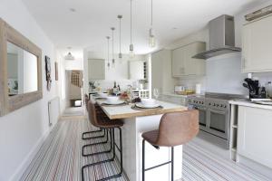 a kitchen with white cabinets and a large island with bar stools at Sandy Feet Retreat in Exmouth