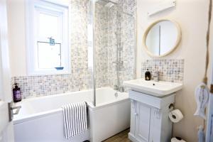 a bathroom with a tub and a sink and a mirror at Sandy Feet Retreat in Exmouth +17 photos