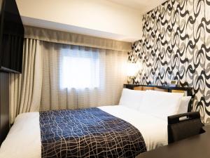 a hotel room with a bed and a window at APA Hotel Kanazawa Ekimae in Kanazawa +94 photos