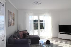 a living room with a couch and a large window at Eifler - Sonnenfels in Gerolstein