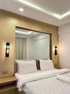 a bedroom with two beds and a large mirror at LuX EXECUTIVE 2 BEDROOM in Eldoret