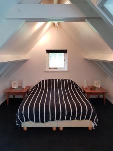 a bedroom with a large bed in a attic at Sleep en Go in Galder