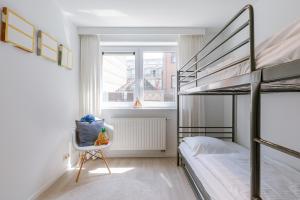 a bedroom with a bunk bed and a chair at Blankeduyn Koksijde in Koksijde