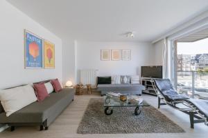 a living room with a couch and a table at Blankeduyn Koksijde in Koksijde