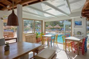 a dining room with a table and chairs and a pool at Spiros-Soula Thematic Suites in Agia Pelagia +104 photos