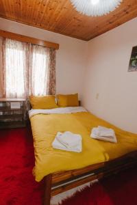una camera da letto con un letto giallo con degli asciugamani sopra di Cuckoo's view a Análipsis