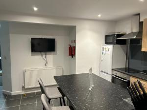 a kitchen with a table and chairs and a refrigerator at The Grove En-Suite Rooms in Bristol