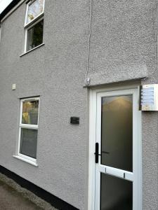 a building with a door and two windows at The Grove En-Suite Rooms in Bristol