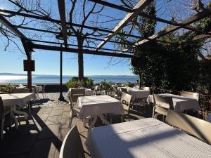 a restaurant with white tables and chairs and the ocean at Lake Suite in Trevignano Romano