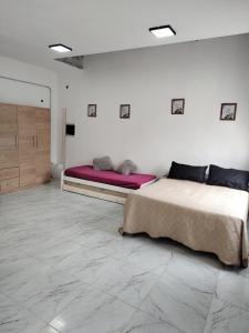 two beds in a white room with marble floors at Quinta la hermosa in Villa María +16 photos