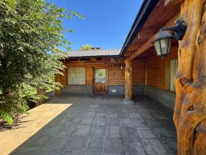 a log house with a porch and a driveway at Cabañas EL CAMPITO in Aluminé