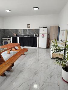 a room with a wooden table and a refrigerator at Quinta la hermosa in Villa María
