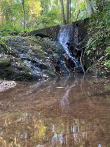 a waterfall on the side of a river at Made in Roça in Piedade +2 photos