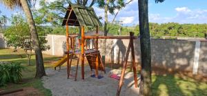 a playground with a wooden swing set in a yard at Chácara Maira e Araken in Ibiúna