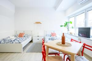 a bedroom with two beds and a table and chairs at The LOFT Apartments Ljubljana in Ljubljana