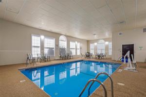 a pool with chairs and tables in a building at Best Western Crown Inn & Suites - Batavia in Batavia