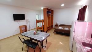 a kitchen and living room with a table and a refrigerator at Complejo CRISMAR in Las Grutas
