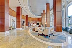 a lobby of a hotel with a table and chairs at 2B Beachfront condo! Pool! Games! 15 mins to PBI! in Riviera Beach