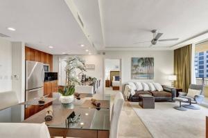 a living room with a couch and a table at 2B Beachfront condo! Pool! Games! 15 mins to PBI! in Riviera Beach