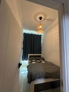 a small bedroom with a bed and a chandelier at Private Room Late checkout 2pm in Abu Dhabi