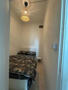 a small bedroom with a bed and a chandelier at Private Room Late checkout 2pm in Abu Dhabi +18 photos