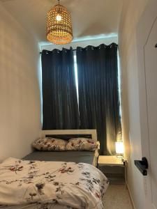 a bedroom with a bed and a window with blue curtains at Private Room Late checkout 2pm in Abu Dhabi