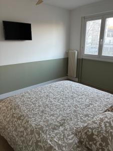 a bedroom with a bed and a flat screen tv at Chez nous Mulhouse - Hyper Centre - Parking - Balcon - Netflix in Mulhouse