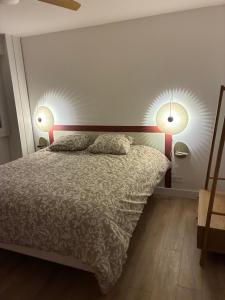 a bedroom with a bed with two lamps on the wall at Chez nous Mulhouse - Hyper Centre - Parking - Balcon - Netflix in Mulhouse
