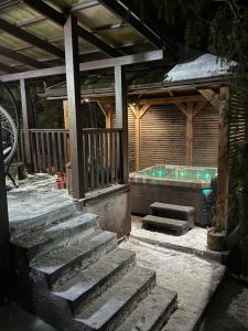 a patio with a hot tub and stairs next to a house at Modern Village in Nowinka