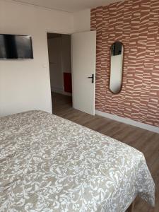 a bedroom with a bed and a wall at Chez nous Mulhouse - Hyper Centre - Parking - Balcon - Netflix in Mulhouse +2 photos
