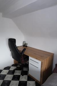 a desk with a chair in a room at Cozy room with bathroom in a private house in Bergrheinfeld