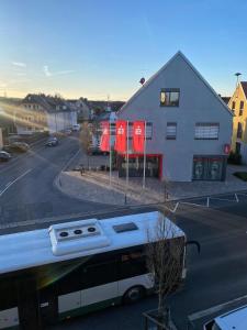 a bus parked in a parking lot next to a building at Cozy room with bathroom in a private house in Bergrheinfeld