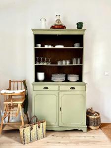 a green cabinet with plates on a shelf at Charming House In Lyons-La-Forêt in Lyons-la-Forêt +5 photos