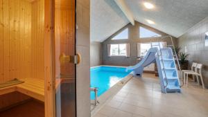 a bathroom with a slide and a swimming pool at Villavilla 474 - Grenå Strand, Østjylland in Grenå