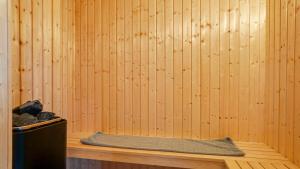 a sauna with a wooden wall and a bench at Villavilla 474 - Grenå Strand, Østjylland in Grenå