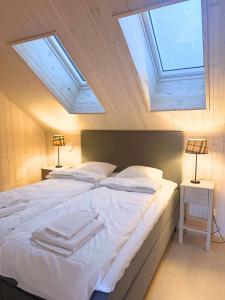 a bedroom with a large white bed with skylights at Alpine Townhouse - Åre Valley Lodges in Åre