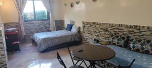 a bedroom with a bed and a table and a couch at DAR LAAZIZA in Meknès +34 photos
