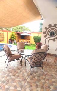 a patio with four chairs and a table and a pool at Hermosa Casa Colibri in Oaxtepec