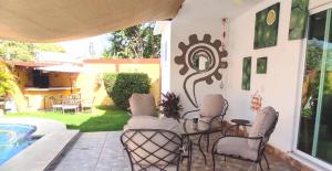 a patio with a table and chairs and a pool at Hermosa Casa Colibri in Oaxtepec