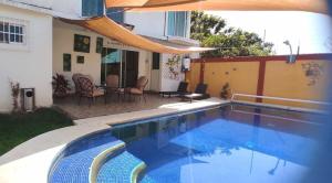 a swimming pool in the backyard of a house at Hermosa Casa Colibri in Oaxtepec