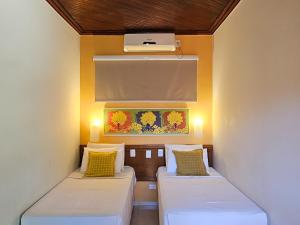 two beds in a room with yellow walls at Pantanal Hotel in Miranda +39 photos