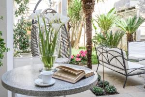 - une table avec un livre et une tasse de café sur la terrasse dans l'établissement Palazzo Dei Dondoli, à Lecce