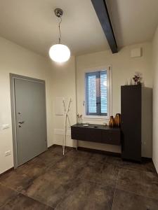 an empty room with a black cabinet and a window at Emilia94 in Anzola dell'Emilia