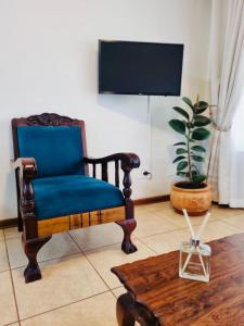 a living room with a blue chair and a table at Bultpark Apartment in Potchefstroom