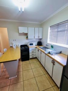 a kitchen with white cabinets and a counter top at Bultpark Apartment in Potchefstroom +15 photos