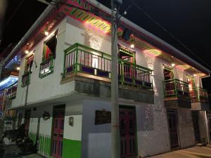 a white building with red and green doors and windows at Rincon del descanso in Salento