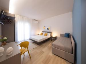 a bedroom with two beds and a table and chairs at Domus Eterea in Marsala