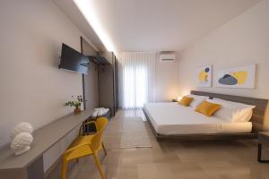 a bedroom with a bed and a yellow chair at Domus Eterea in Marsala
