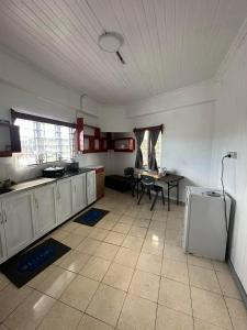 a kitchen with white cabinets and a table in it at YaNuYaNu Appartment Nabua in Suva